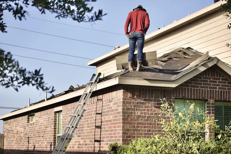 Professional roofer working on a residential roof in South Fork